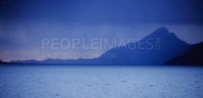 Buy stock photo Peaceful and scenic coastal bay at midnight. Beautiful landscape of a mountain near the sea in the evening with copy space. Scenic view of the ocean with dark blue sky during the night and copyspace