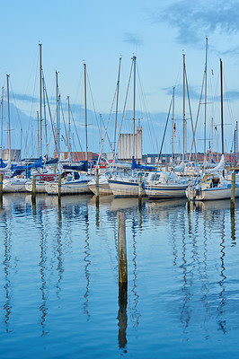 Buy stock photo Group of boats docked in a harbor of Bodo. Scenic view of sailing yachts in cruise port and bay at dusk. Rippled water and sky in oceanside port for fishing or traveling abroad for vacation