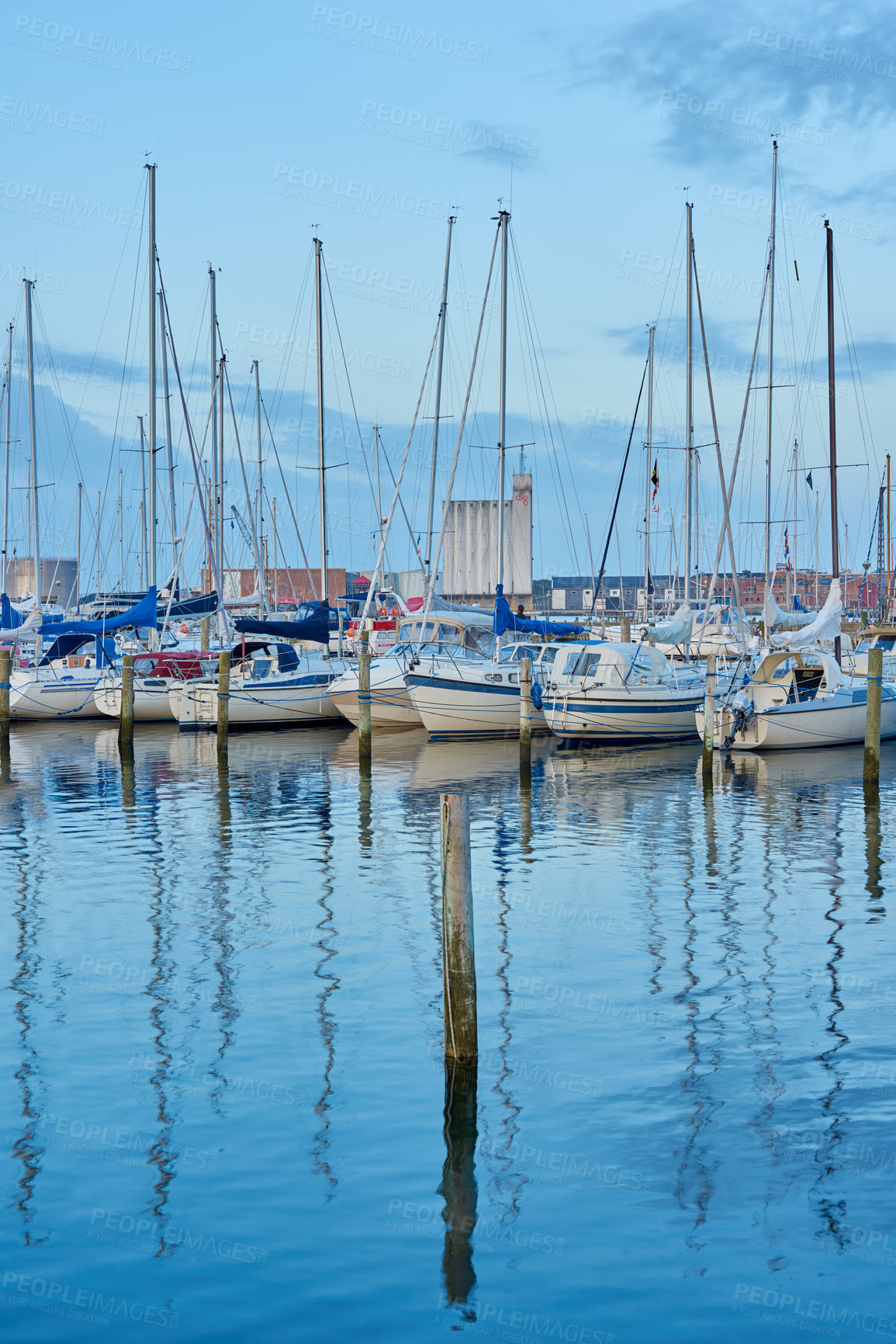 Buy stock photo Group of boats docked in a harbor of Bodo. Scenic view of sailing yachts in cruise port and bay at dusk. Rippled water and sky in oceanside port for fishing or traveling abroad for vacation