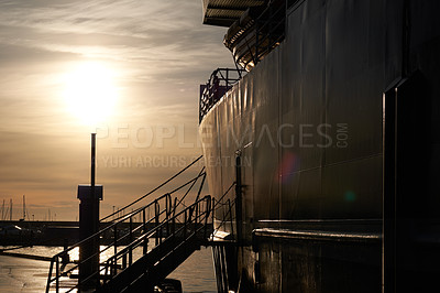 Buy stock photo Silhouette of a cruise ship and boat docked at sea along the harbor in Bodo, Nordland, Norway at sunset with copy space. Scenic waterfront port at a marina dockyard ready for tourism travel