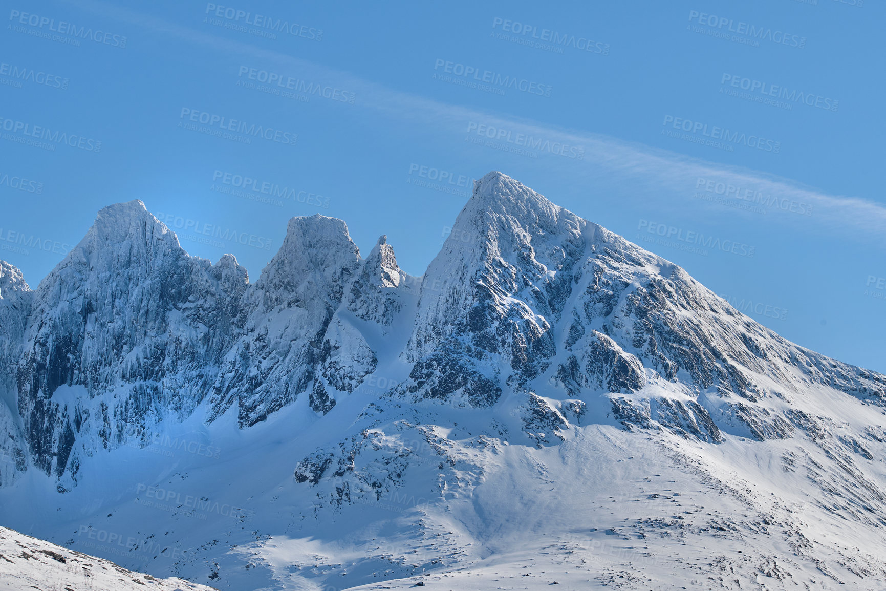 Buy stock photo A cold mountain peak covered in snow during winter with a blue sky background. Beautiful landscape of a snowy summit with freezing weather conditions in the morning outdoors in nature 