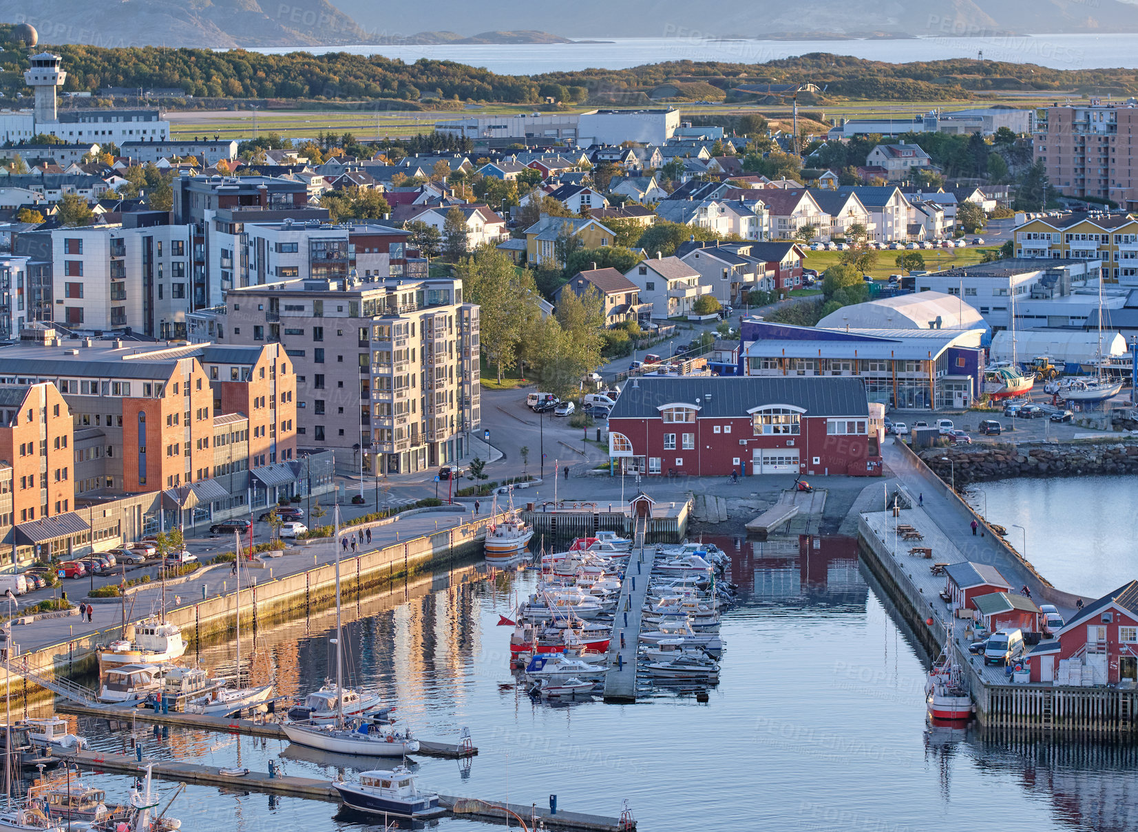 Buy stock photo The landscape of the harbor in the city of Bodo on a summer day. A small port in an urban town with boats, buildings, and streets. Aerial view of a scenic location near mountain and nature