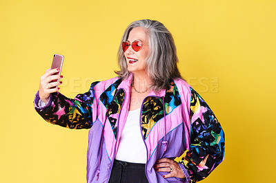 Buy stock photo Cropped shot of a confident and stylish senior woman taking selfies against a yellow background