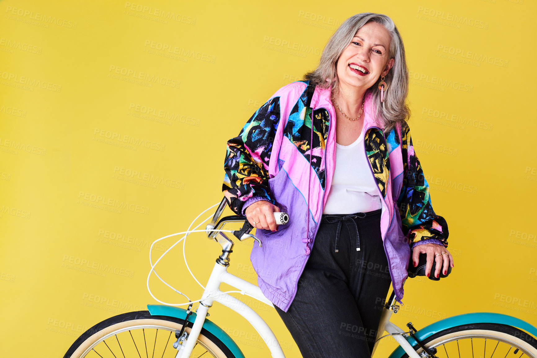 Buy stock photo Portrait of a confident and stylish senior woman posing with her bicycle against a yellow background