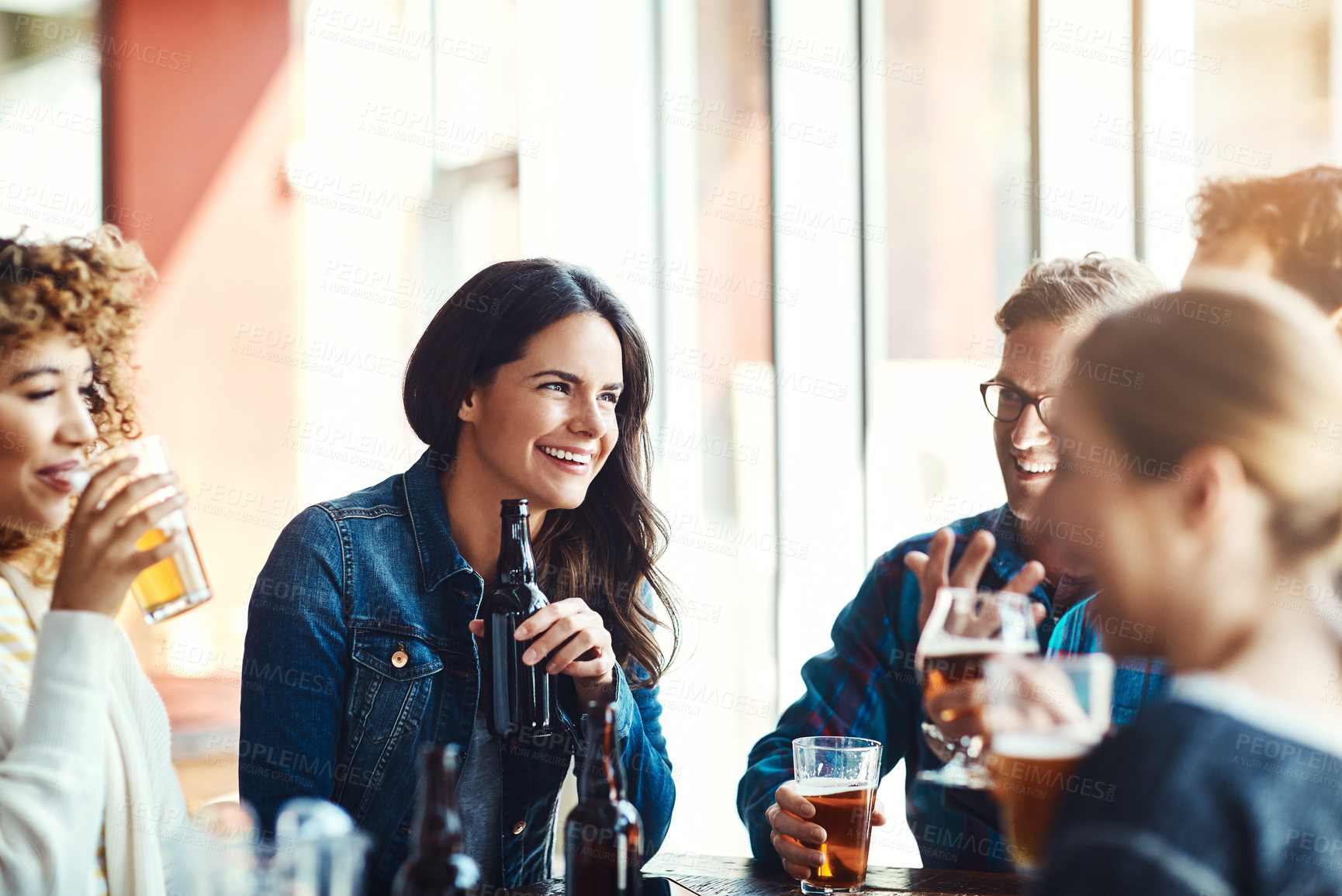 Buy stock photo Shot of a group of friends enjoying some beers at a bar