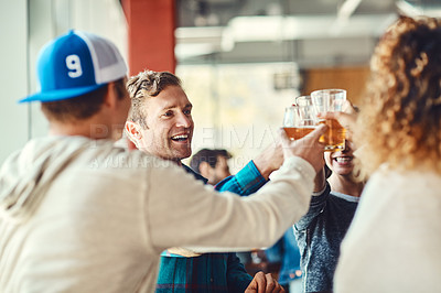 Buy stock photo Shot of a group of happy friends toasting with beers at a bar