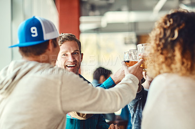 Buy stock photo Shot of a group of happy friends toasting with beers at a bar