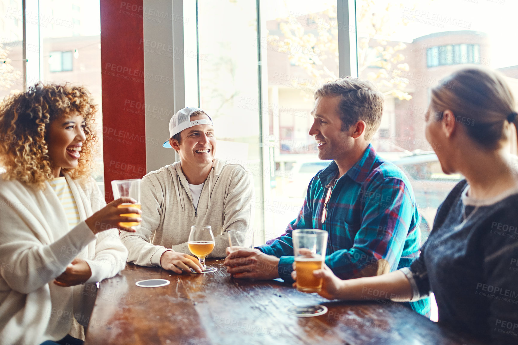 Buy stock photo Shot of a group of friends enjoying some beers at a bar