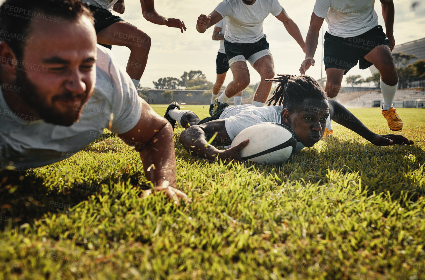 Buy stock photo Cropped shot of a group of handsome young rugby players training together on the field