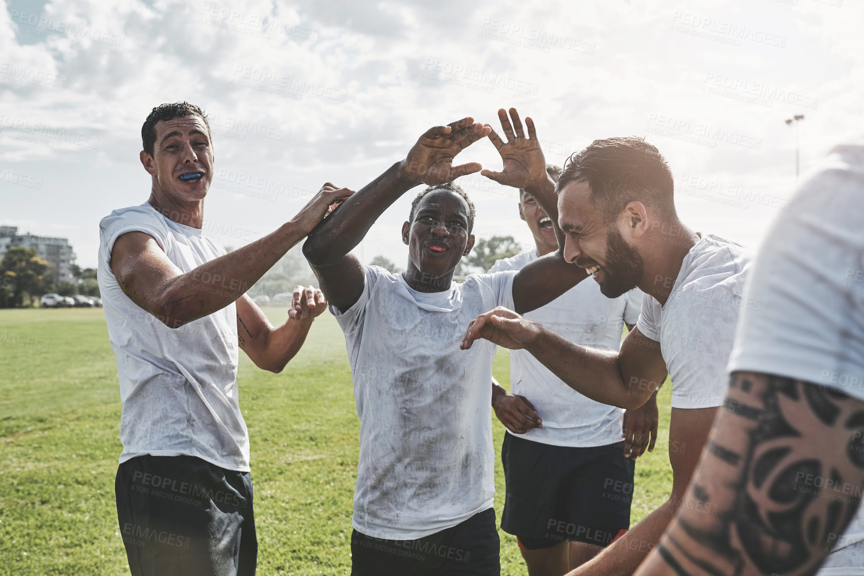 Buy stock photo Cropped shot of a group of cheerful young rugby players celebrating their win after a match outside during the day