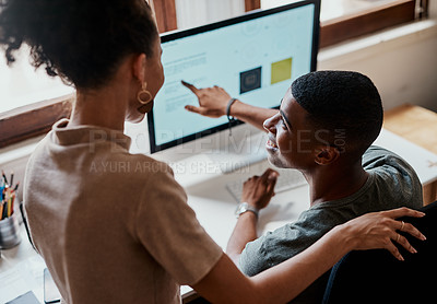 Buy stock photo Shot of a young businessman and businesswoman using a computer together in a modern office