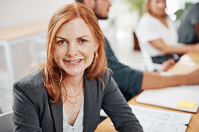 Buy stock photo Portrait of a mature businesswoman sitting in an office with her colleagues in the background