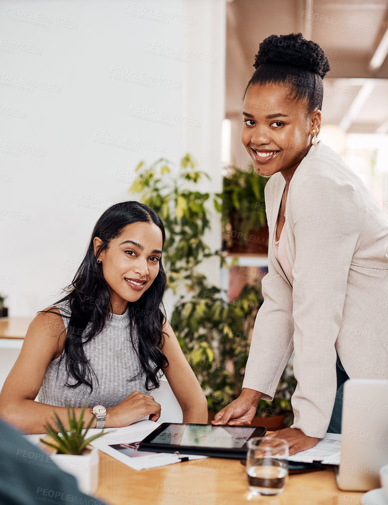 Buy stock photo Portrait of two businesswomen working together on a digital tablet in an office