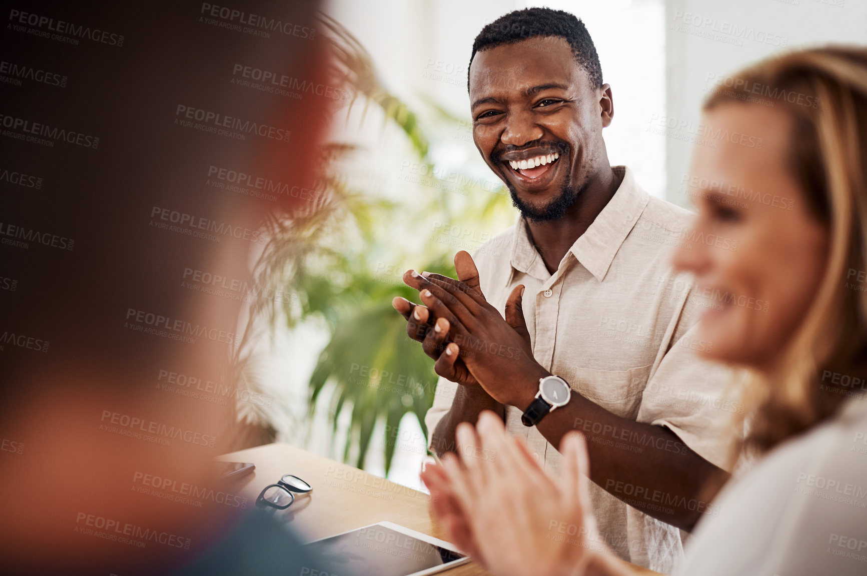 Buy stock photo Shot of a young businessman applauding during a meeting in an office