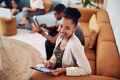 Buy stock photo Cropped portrait of an attractive young businesswoman sitting and using a tablet while her colleagues work behind her