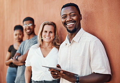 Buy stock photo Cropped portrait of a handsome young businessman standing with his colleagues outside and using a tablet