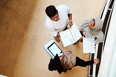 Buy stock photo High angle shot of a group of businesspeople having a discussion while going through paperwork together in an office
