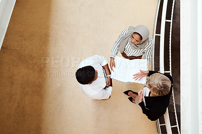 Buy stock photo High angle shot of a group of businesspeople having a discussion while going through paperwork together in an office