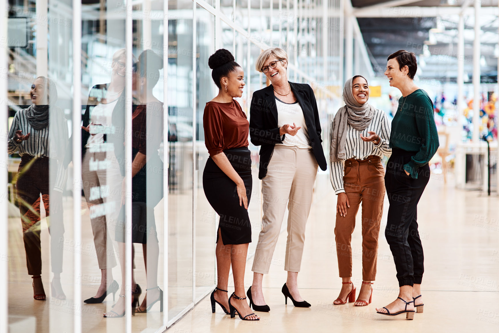 Buy stock photo Shot of a group of businesswomen chatting to each other in an office