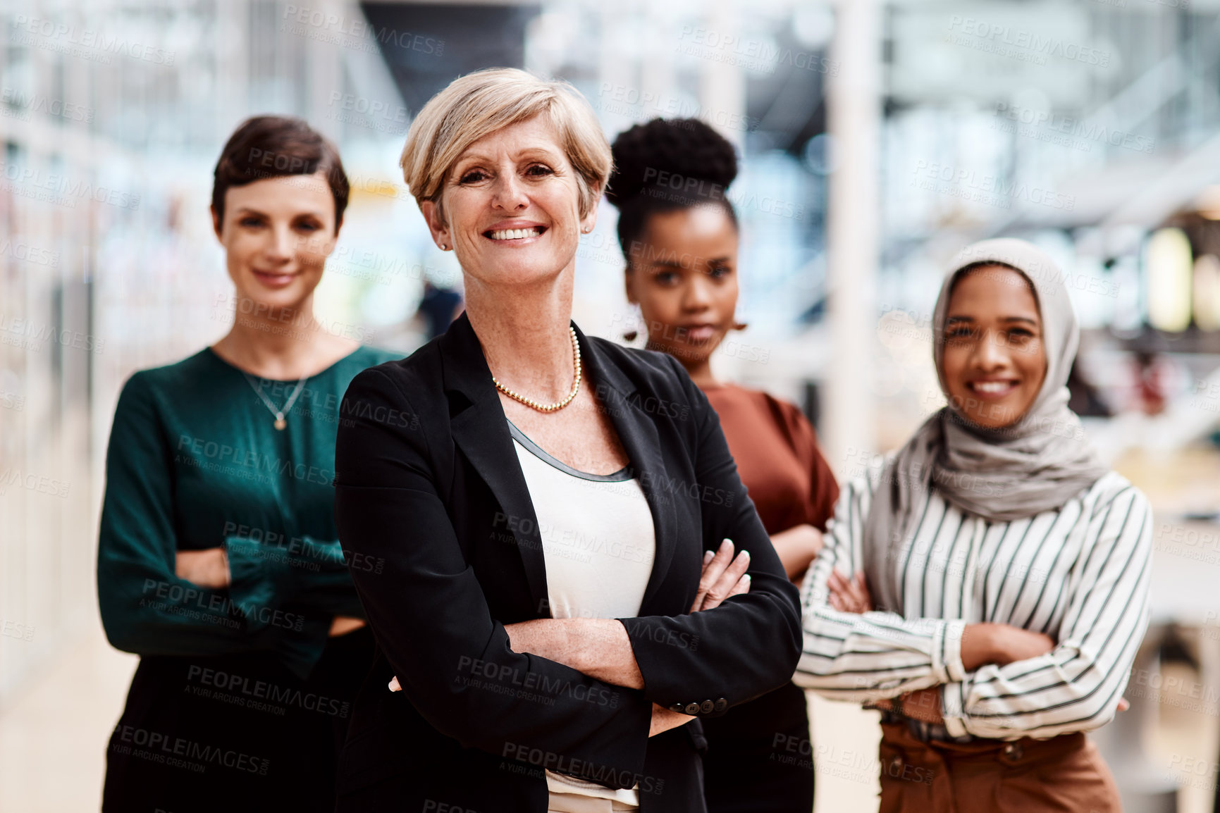 Buy stock photo Portrait of a mature businesswoman standing in an office with her colleagues in the background