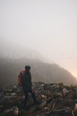 Buy stock photo Shot of a man wearing his backpack while out for a hike in the mountains with his dog