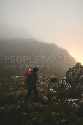 Buy stock photo Shot of a man wearing his backpack while out for a hike in the mountains