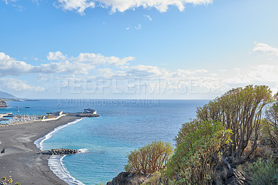 Buy stock photo Scenic seaside and seascape of touristic coastal city of Puerto de Tazacorte in La Palma, Spain during summer. Landscape view of a sea with a black sand beach, a blue sky with clouds and copy space. 