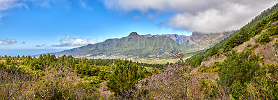 Buy stock photo Scenic landscape of mountains in La Palma, Canary Islands, Spain against a cloudy blue sky background with copyspace. Wild plants and shrubs growing on a rocky hill and cliff in natural environment
