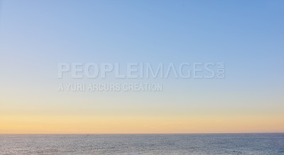 Buy stock photo Seascape of a beautiful golden sunset with copy space. Sun setting on the horizon of a calm ocean at dusk or twilight. The calm and tranquil ocean or sea in the evening with bright sky copyspace