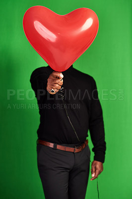 Buy stock photo Celebration, green screen and person with balloon for valentines day, anniversary and formal fashion. Studio, man and male model with heart inflatable for face cover, hide and isolated background