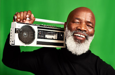 Buy stock photo Studio shot of a senior man holding up a vintage radio against a green background