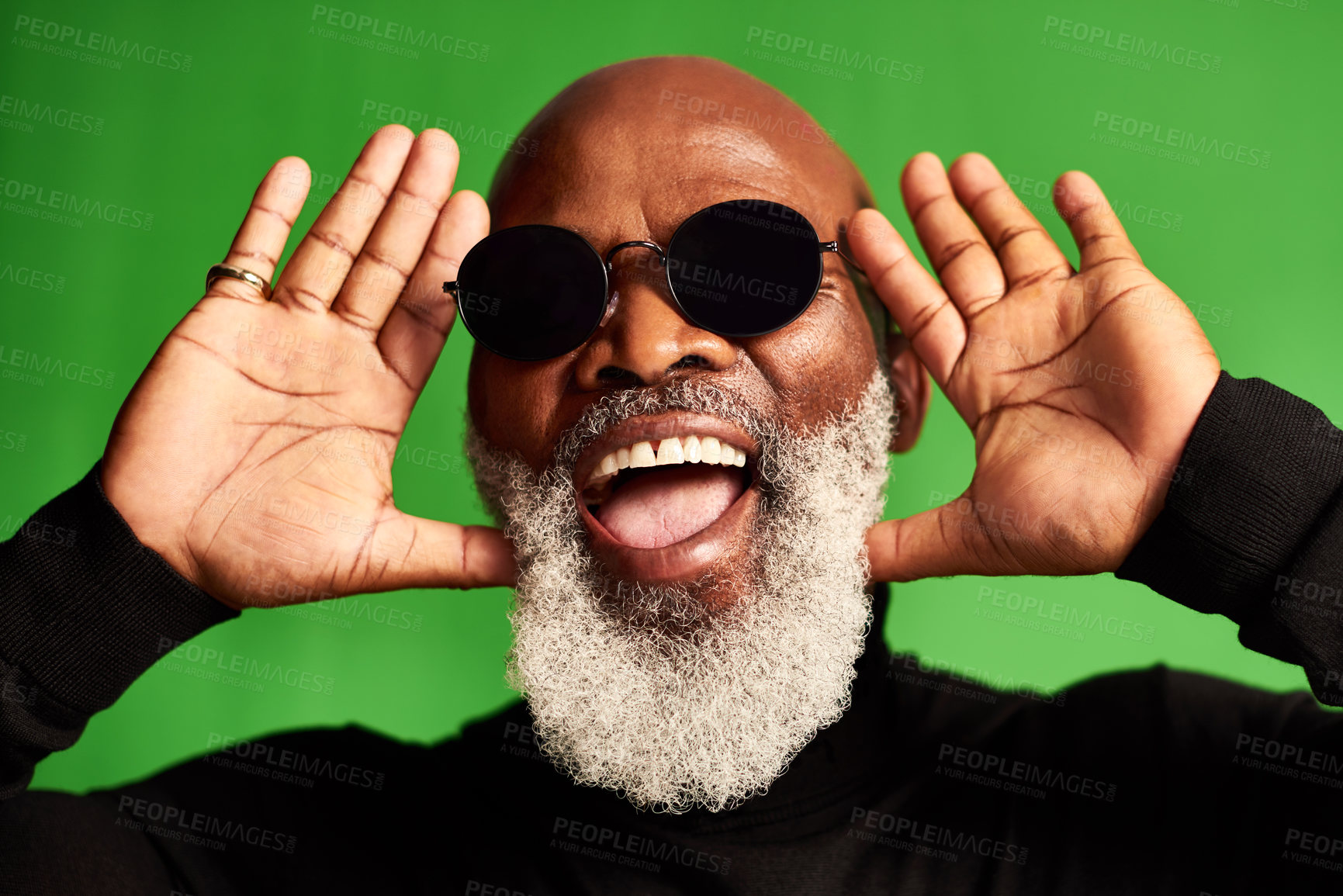 Buy stock photo Studio shot of a senior man wearing glasses and making funny faces against a green background