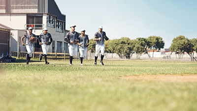 Buy stock photo Shot of a group of young men walking onto a baseball field
