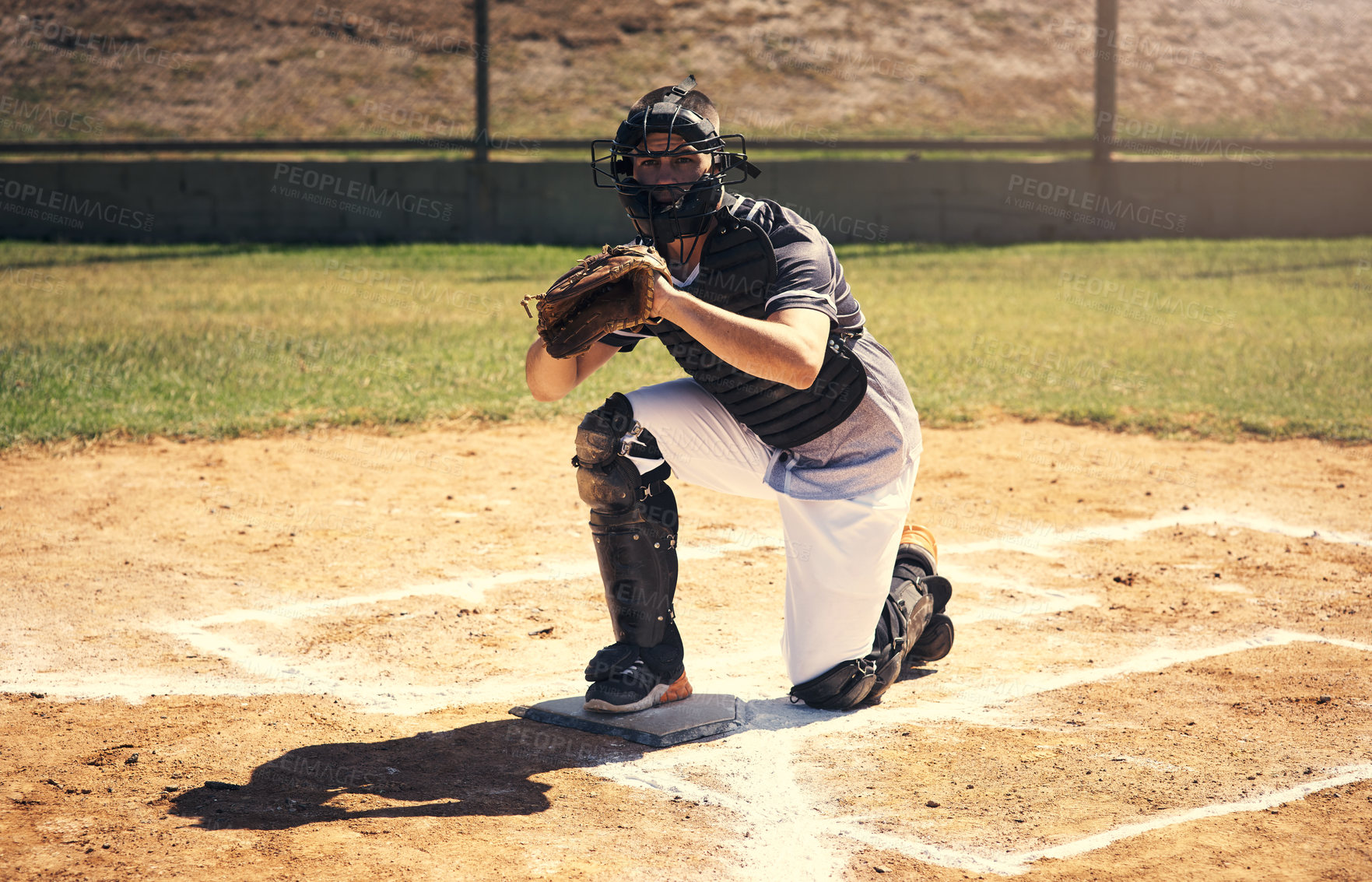 Buy stock photo Shot of a young man catching a ball during a baseball match