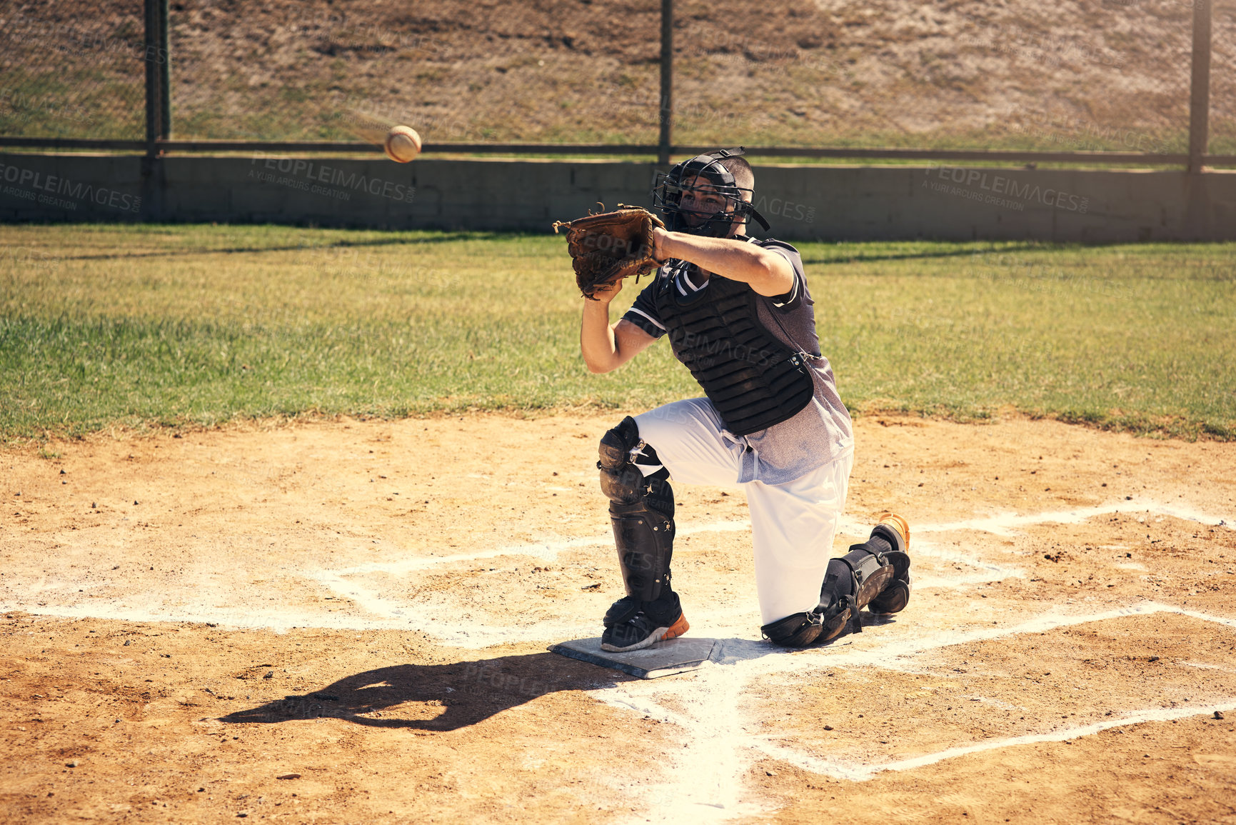 Buy stock photo Shot of a young man catching a ball during a baseball match