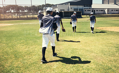 Buy stock photo Rearview shot of a group of young men walking onto a baseball field