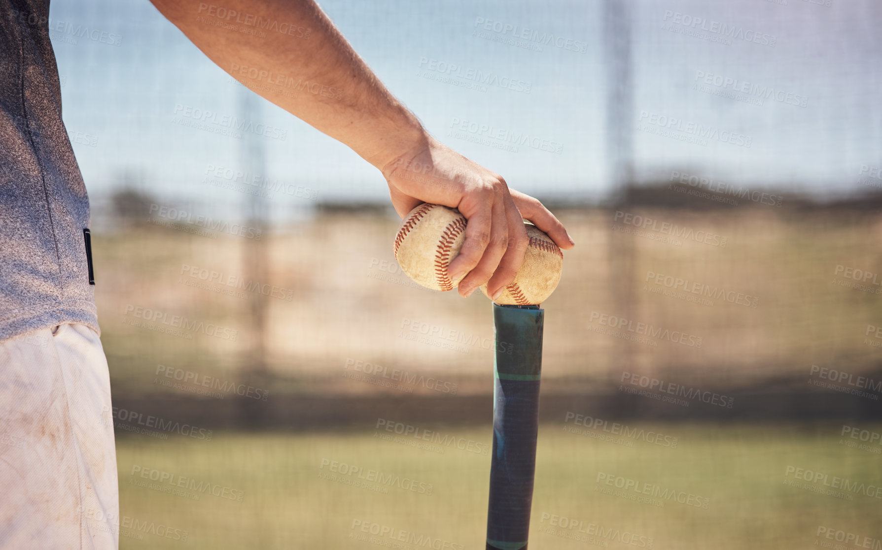 Buy stock photo Cropped shot of a man holding a ball on top of his batting tee at a baseball game