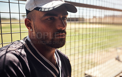 Buy stock photo Shot of a young man sitting in the dugout at a baseball game