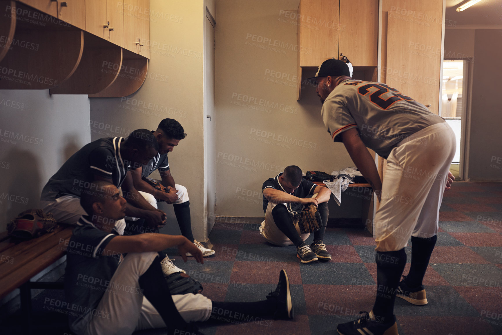 Buy stock photo Shot of a young man yelling at his fellow baseball players in a locker room