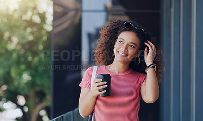 Buy stock photo Cropped shot of a young woman holding a takeout coffee while walking through the city