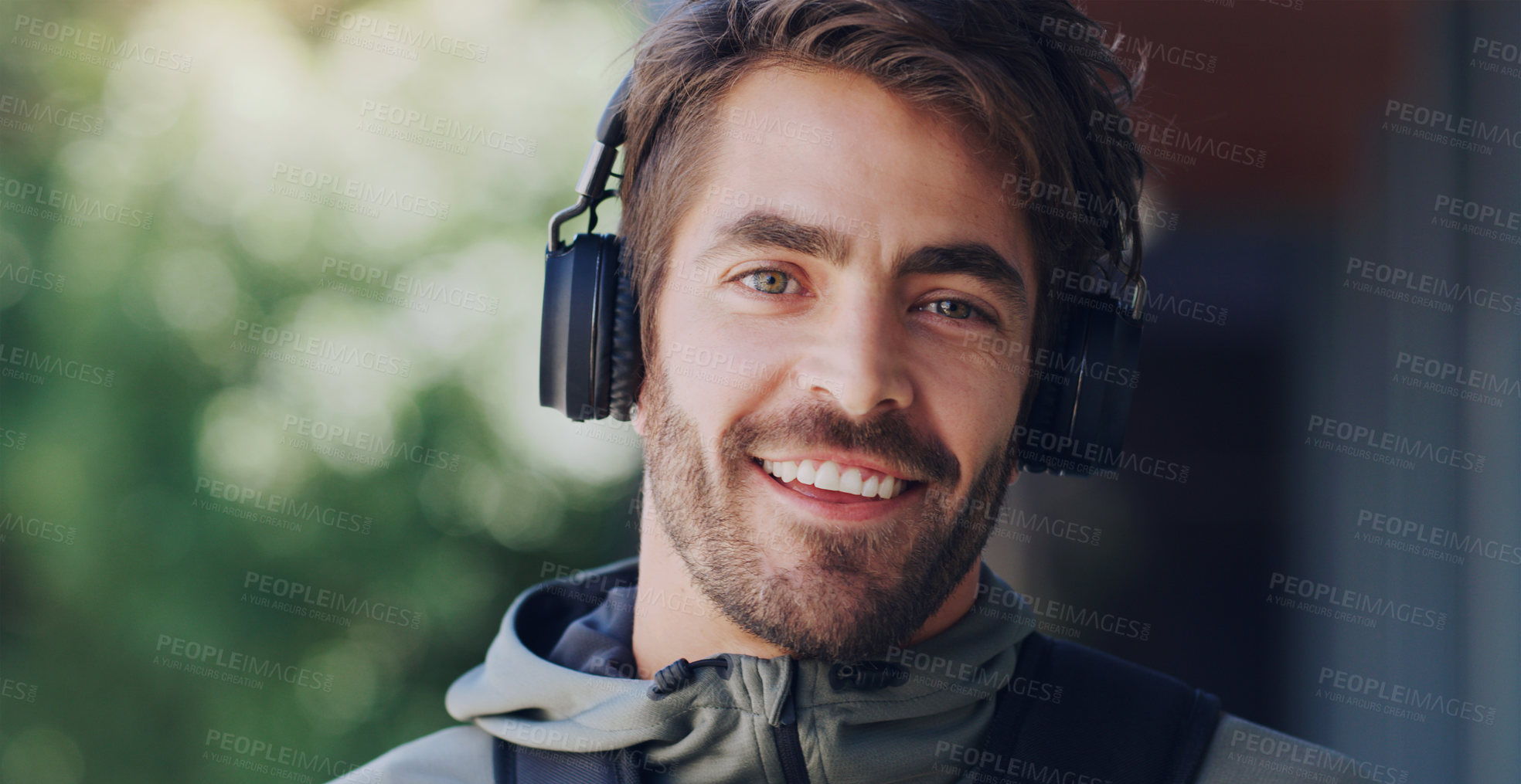Buy stock photo Cropped shot of a young man wearing headphone while walking through the city