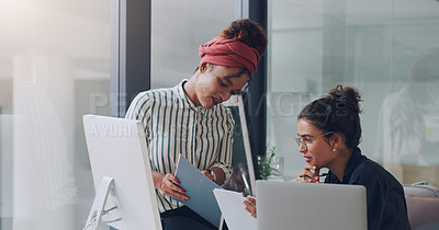 Buy stock photo Cropped shot of two attractive young businesswomen working together in the office