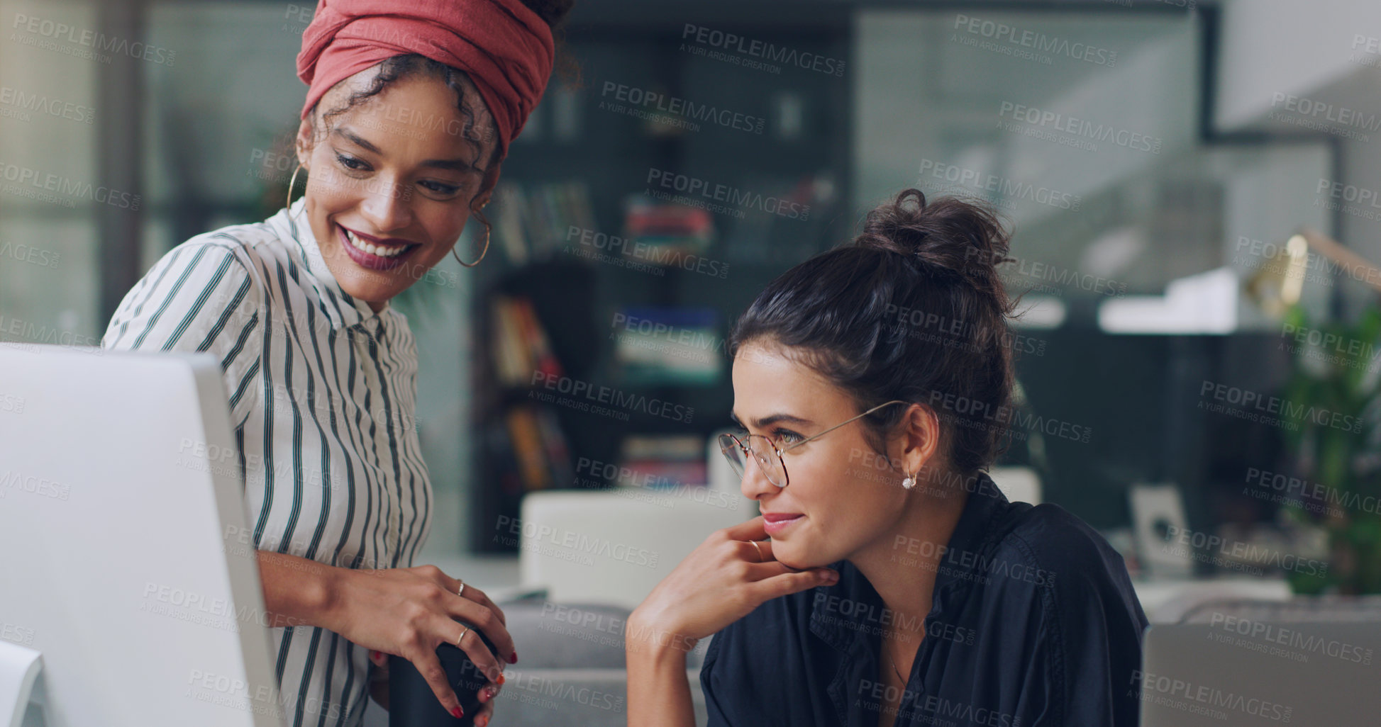 Buy stock photo Cropped shot of two attractive young businesswomen working together in the office
