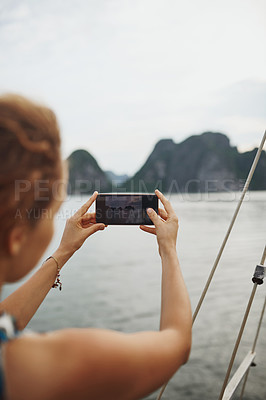 Buy stock photo Shot of a young woman taking pictures of a river in Vietnam with her smartphone