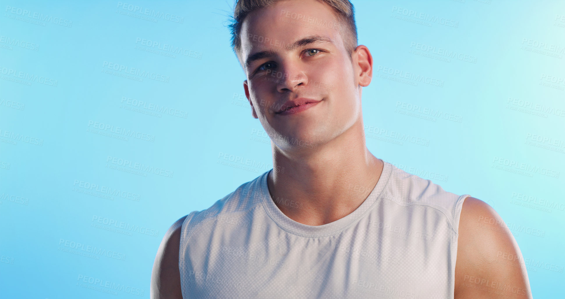 Buy stock photo Studio portrait of a handsome young man posing against a blue background