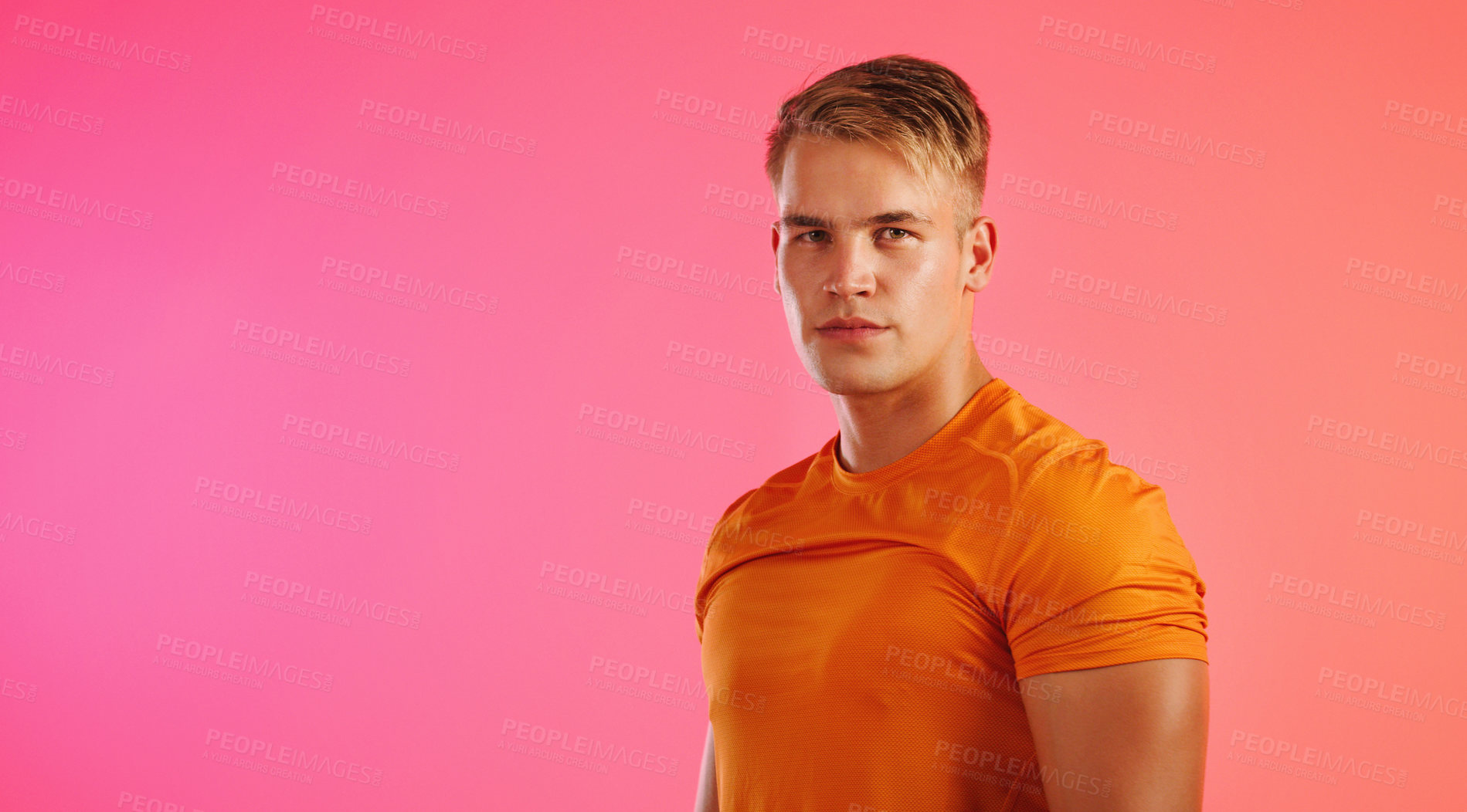 Buy stock photo Studio portrait of a handsome young man posing against a peach background