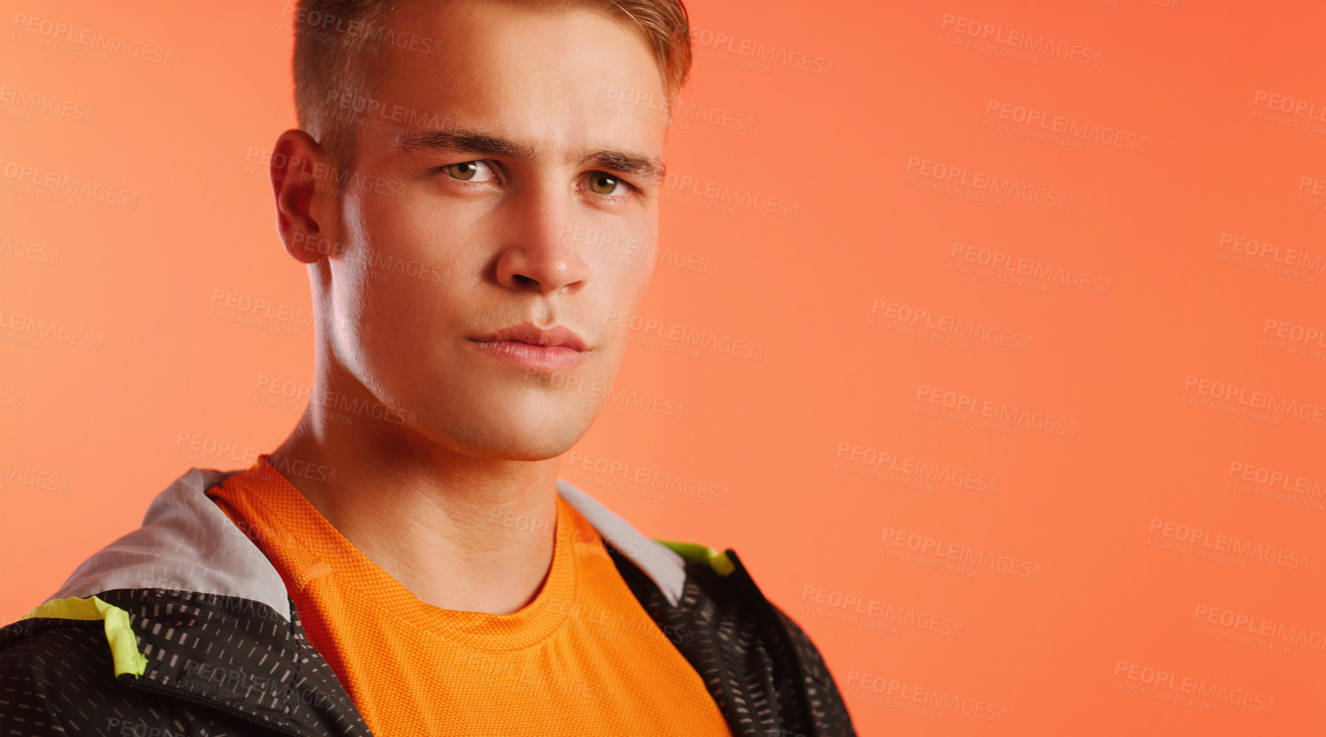 Buy stock photo Man, portrait and fashion in studio for fitness, style or winter outfit for confidence or sport. Raincoat, hoodie and athlete for workout or exercise, training and mockup by orange background