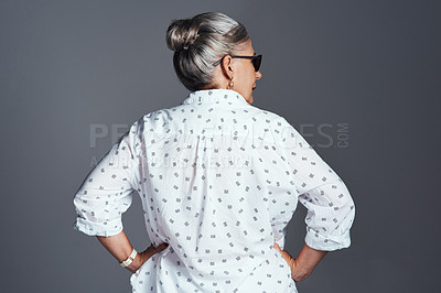 Buy stock photo Rearview shot of a senior woman wearing sunglasses while posing against a grey background