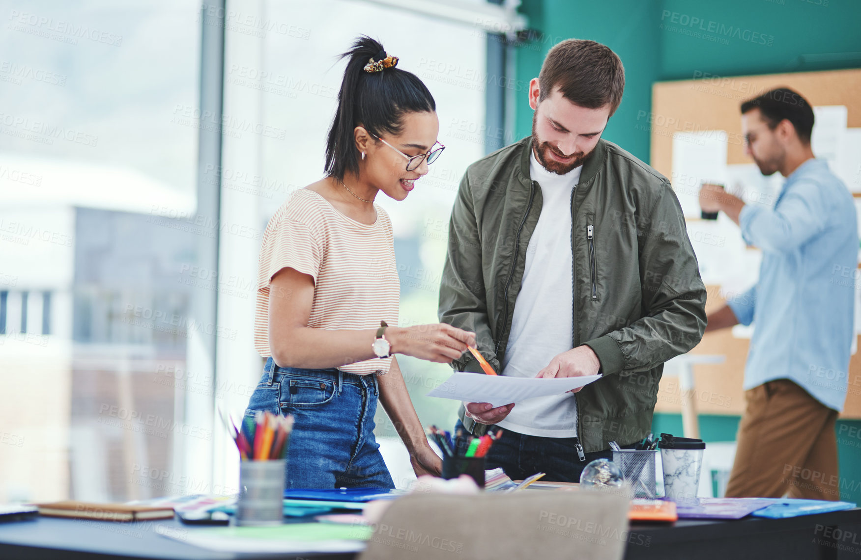 Buy stock photo Shot of two designers going through paperwork together in an office