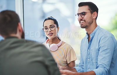 Buy stock photo Shot of a group of young designers having a discussion in an office